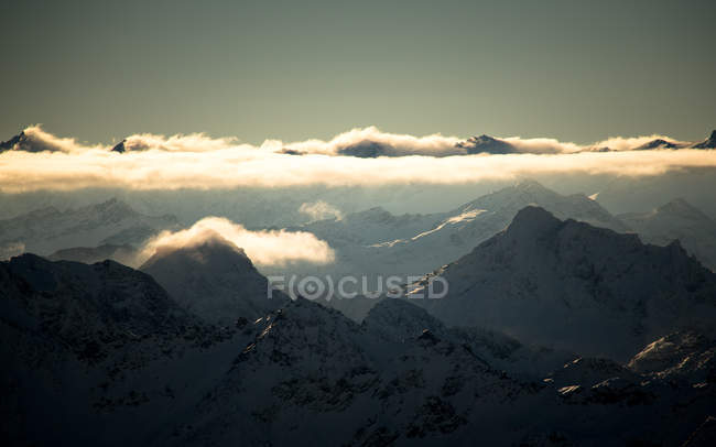 Pics alpins dans les nuages dorés — Photo de stock