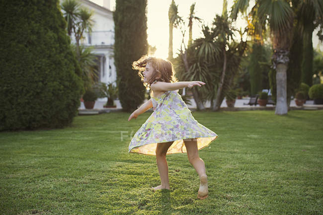 Girl spinning around in garden — Stock Photo