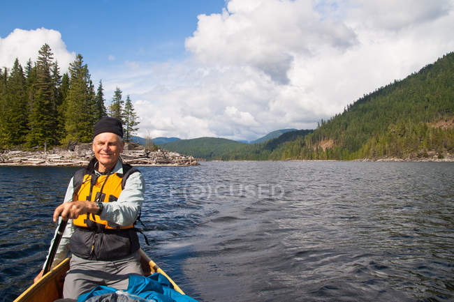 Paleador de canoa en el lago - foto de stock