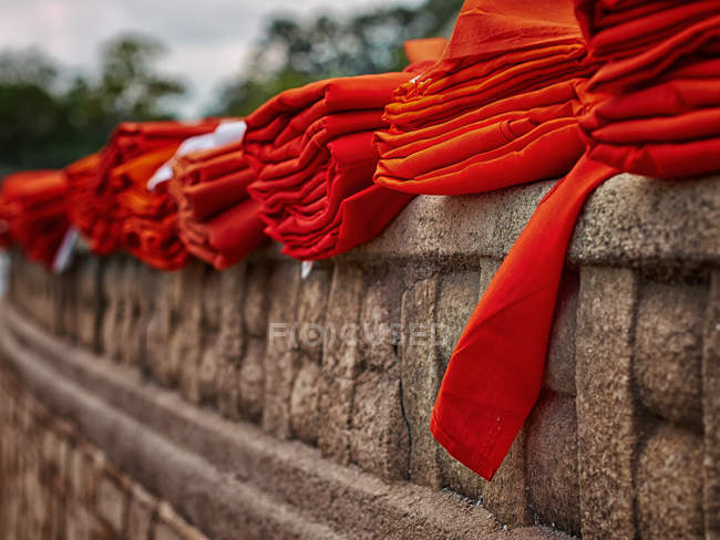 Roben roter Mönche auf befestigter Mauer — Stockfoto
