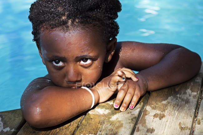 Mädchen lehnt am Rand eines Pools — Stockfoto