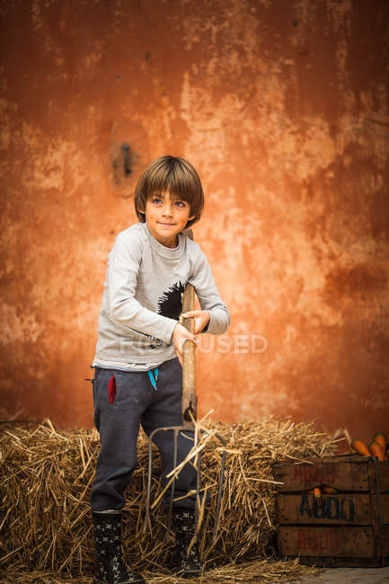 Junge mit Heuhaufen und Mistgabel — Stockfoto