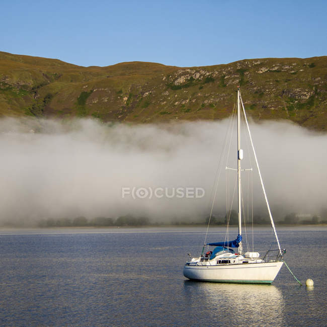 Sailboat on loch with fog — Stock Photo