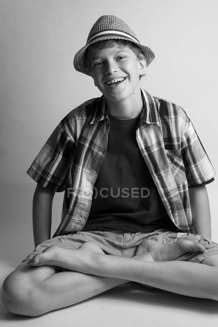 Boy laughing while sitting cross-legged — Stock Photo