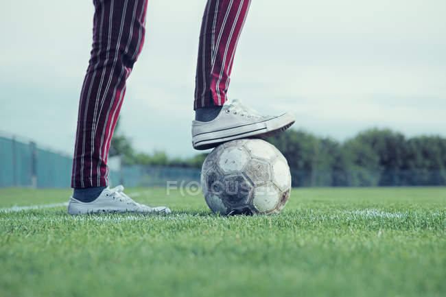 Pierna masculina en pelota de fútbol - foto de stock