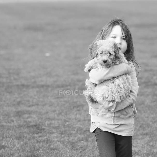 Girl carrying dog — Stock Photo
