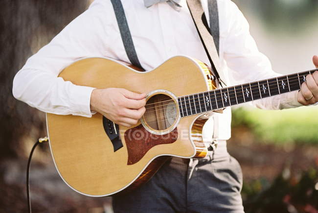 Hombre tocando una guitarra acústica - foto de stock