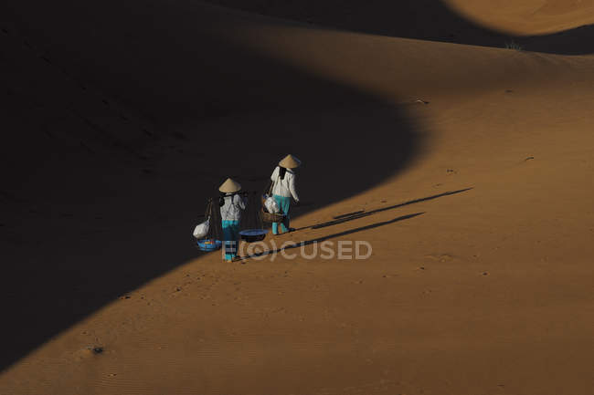 Люди ходят по песку — стоковое фото