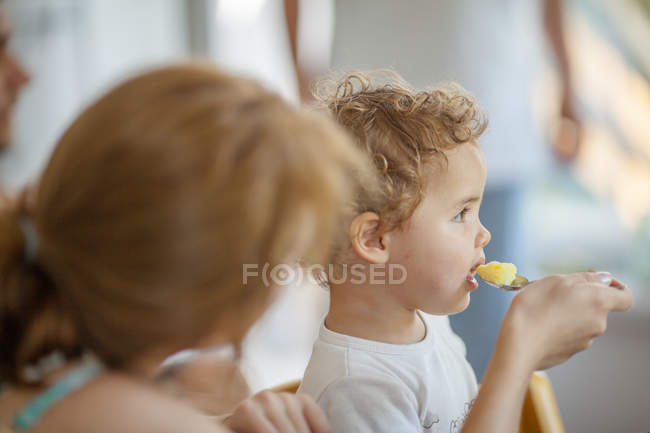 Mãe alimentando bebê menina com colher — Fotografia de Stock