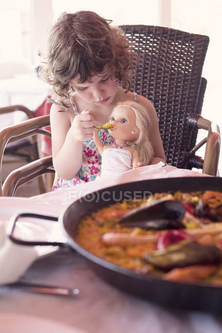 Menina alimentando sua boneca — Fotografia de Stock
