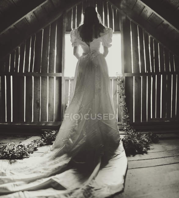 Mujer en vestido de novia en el ático - foto de stock