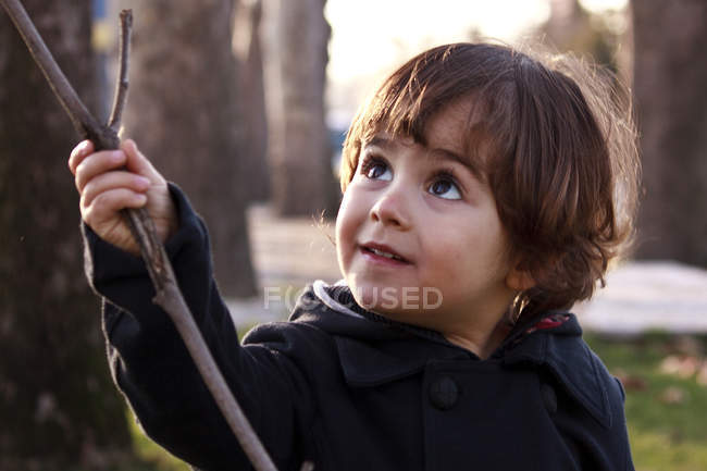 Niño con palo en el parque - foto de stock