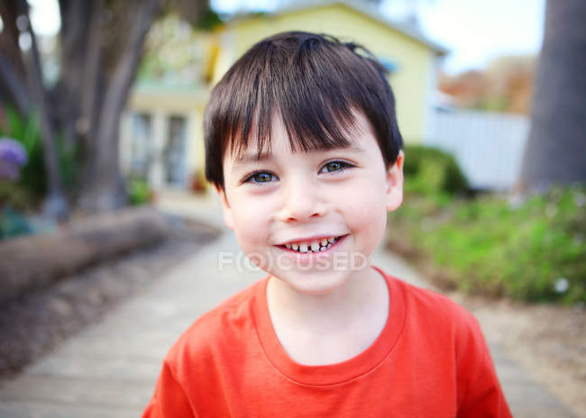 Petit garçon souriant à la caméra dans le parc — Photo de stock