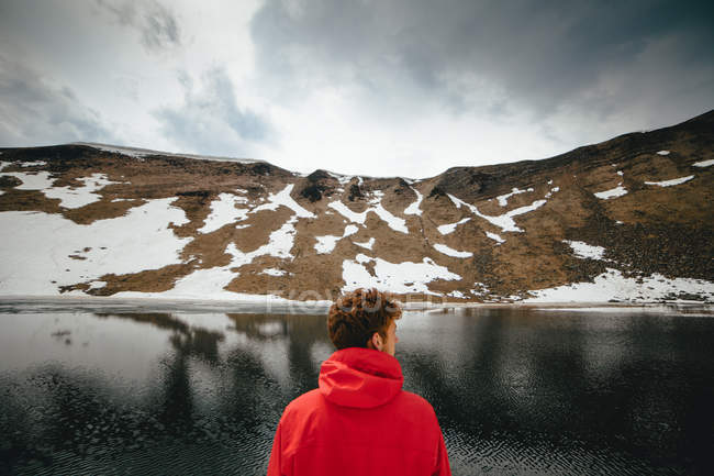 Homme regardant lac de montagne — Photo de stock