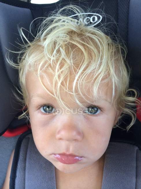 Unhappy boy in car seat — Stock Photo