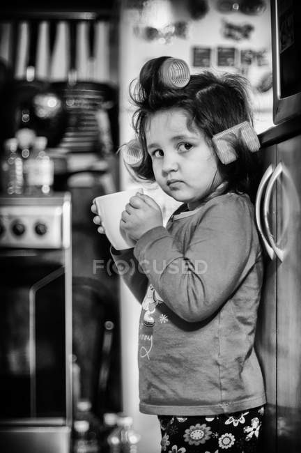 Девушка за чашкой кофе и смотрит в камеру — стоковое фото