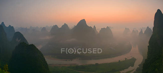 Salida del sol sobre las montañas Karst de China - foto de stock