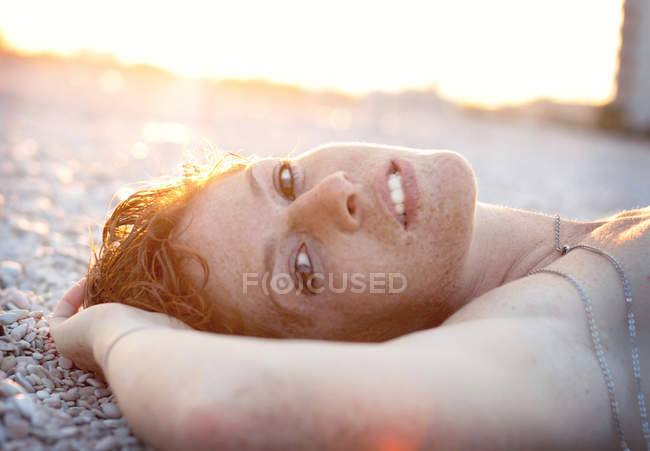 Jeune femme sur la plage de galets — Photo de stock