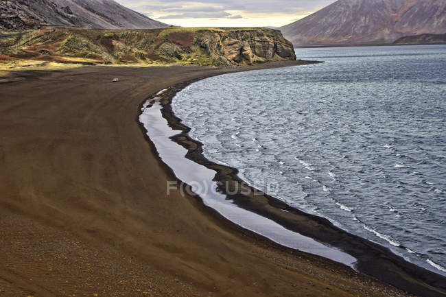 Praia de areia com montanhas — Fotografia de Stock