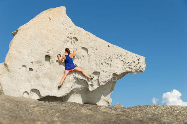 Jovem mulher escalando rocha grande — Fotografia de Stock