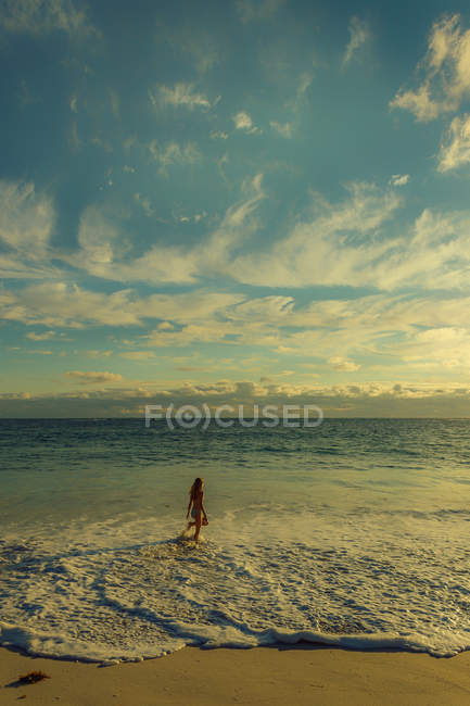 Chica caminando en la playa - foto de stock