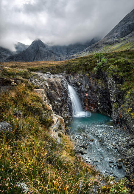 Cachoeira durante o dia nebuloso nas montanhas — Fotografia de Stock