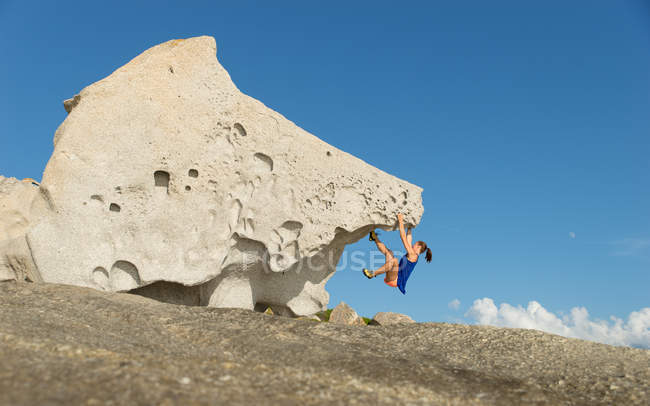 Femme escalade sur grand rocher unique — Photo de stock