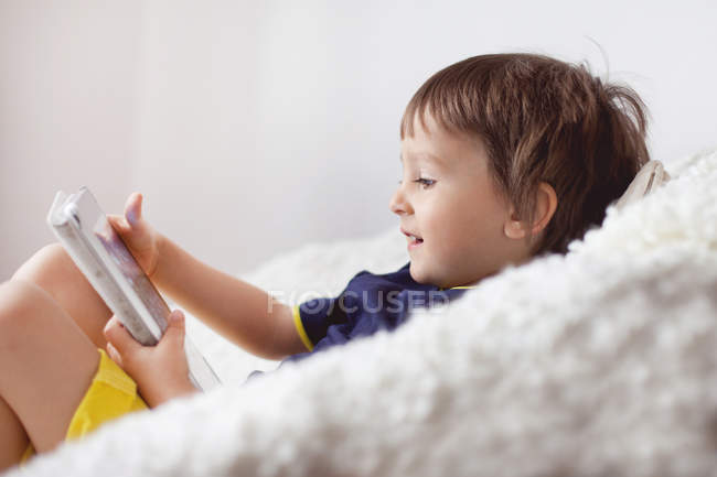Petit garçon utilisant une tablette numérique — Photo de stock
