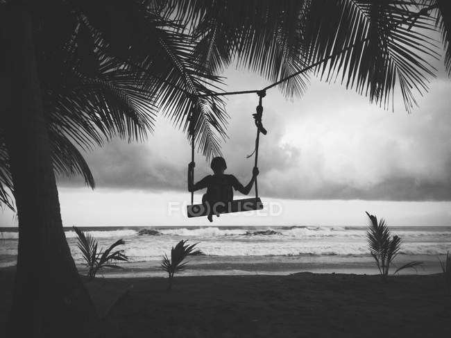 Silhouette of boy on swing — Stock Photo