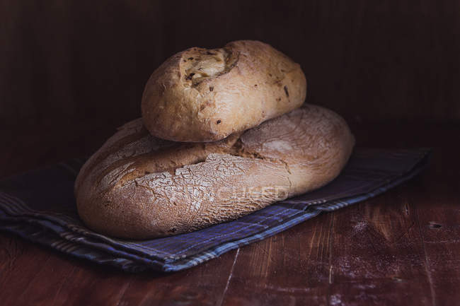 Loaves of bread on tablecloth — Stock Photo