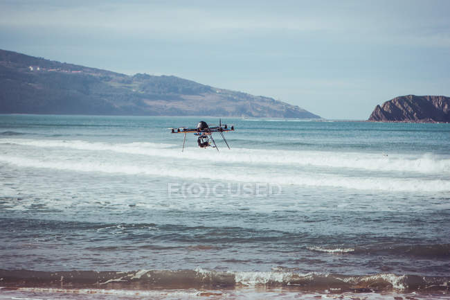 Dron volando sobre el mar - foto de stock