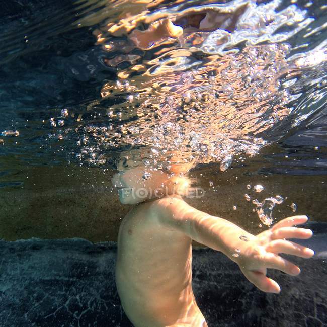 Niño bajo el agua, vista lateral - foto de stock