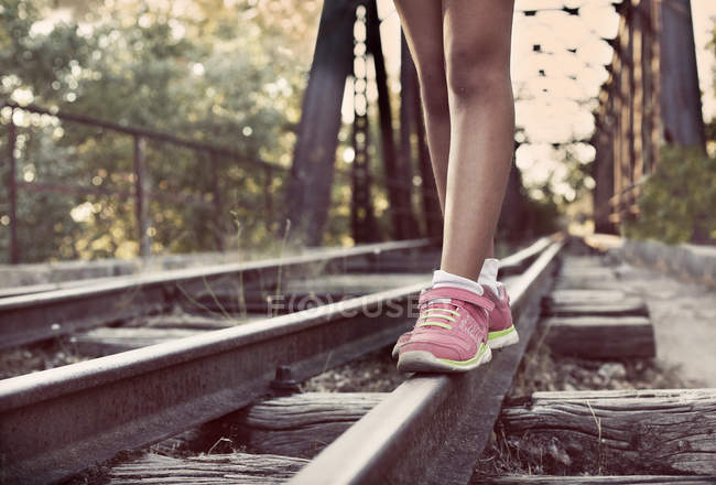 Девушка ходит по железнодорожным путям — стоковое фото