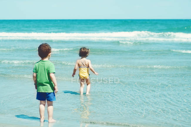 Niños jugando en la playa - foto de stock