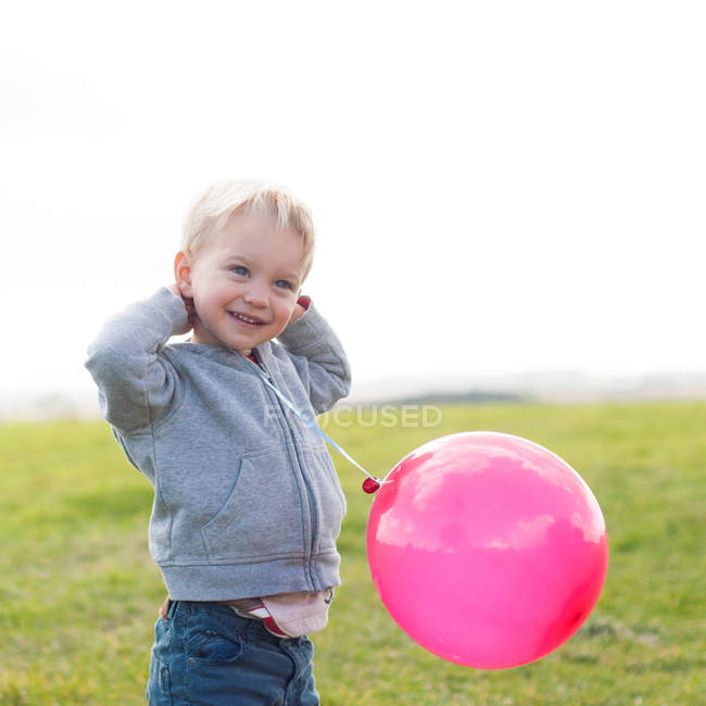 Мальчик с воздушным шаром на улице — стоковое фото