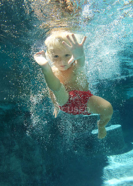 Niño nadando bajo el agua - foto de stock