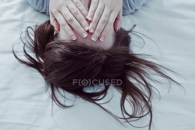 Mujer cubriendo los ojos con las manos - foto de stock