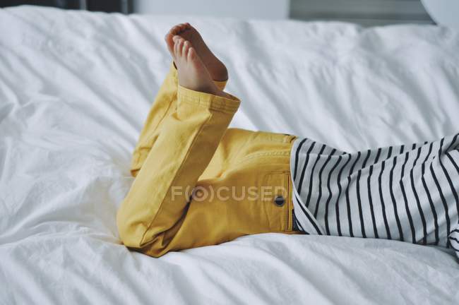 Niño acostado en la cama - foto de stock