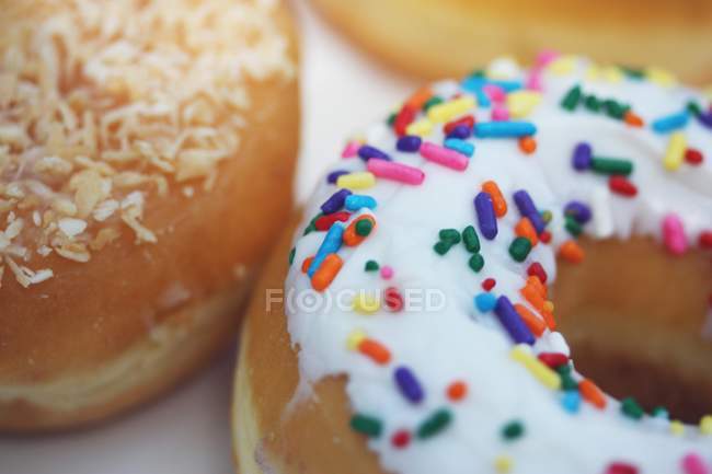 Sprinkled donuts on table — Stock Photo