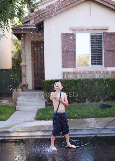 Boy playing with hosepipe — Stock Photo