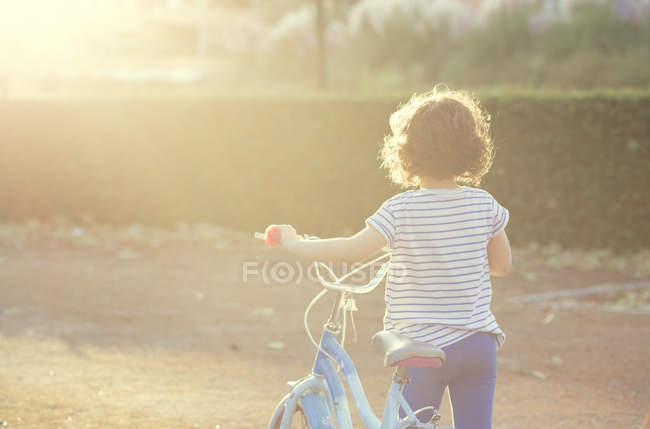 Mädchen läuft mit ihrem Fahrrad — Stockfoto