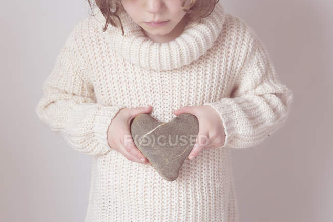 Fille tenant coeur en forme de pierre — Photo de stock