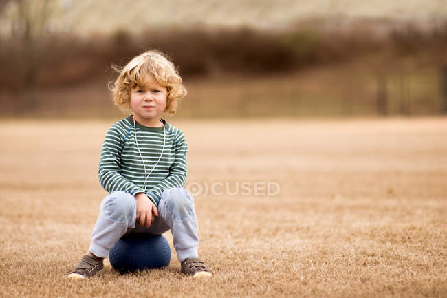 Мальчик с мячом в поле — стоковое фото