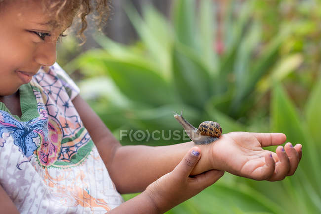 Fille avec escargot sur le bras — Photo de stock