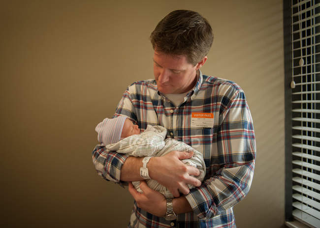 Батько тримає новонароджену дитину — стокове фото