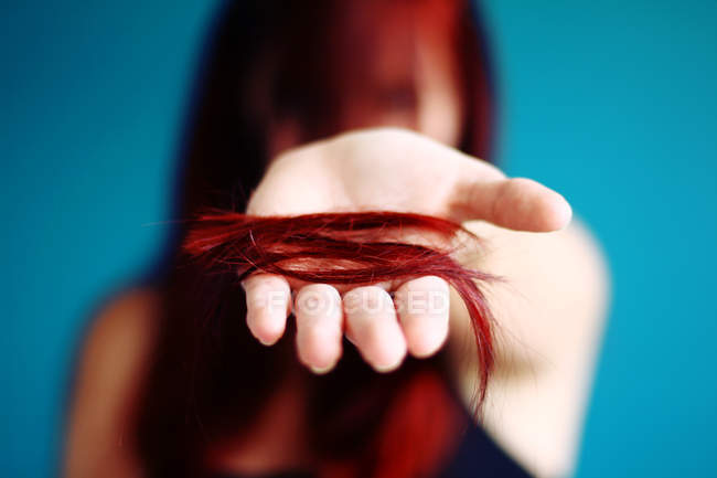Mano femenina sosteniendo el pelo cortado - foto de stock