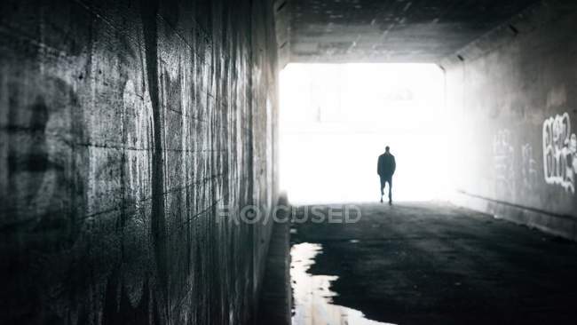 Hombre caminando a través del túnel - foto de stock