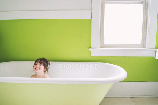 Niña sentada en la bañera - foto de stock