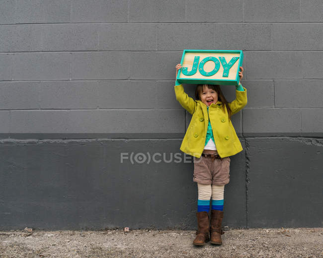 Menina segurando sinal de alegria — Fotografia de Stock