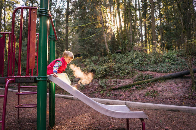 Menino no slide no parque — Fotografia de Stock